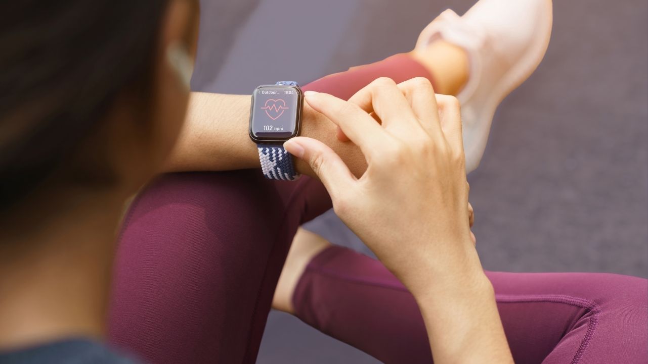 Woman sitting looking at watch for Fitness Trackeing for Sleep and Activity