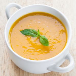 Healthy fall recipes, pumpkin soup in a white bowl.