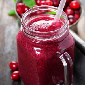 A cranberry sauce smoothie in a mason jar with a straw.