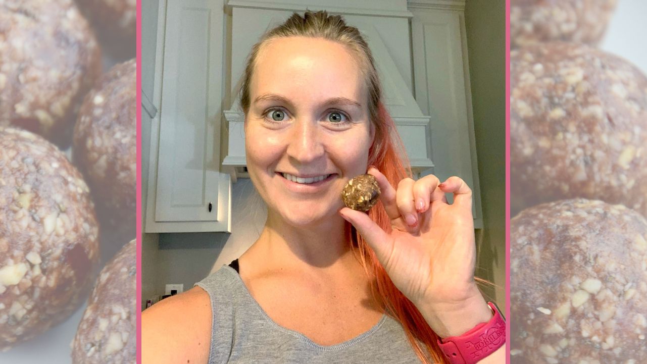 Pilatesbody by Kayla holding up a nut butter protein ball.