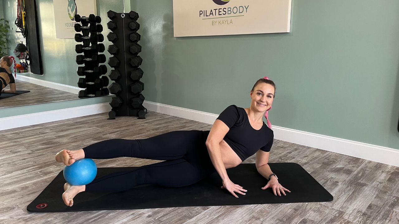 Pilatesbody by Kayla doing mat Pilates with a mini Pilates ball.