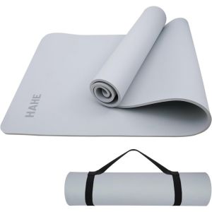 A gray non-slip yoga mat with a strap.