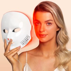 Newkey Red Light Mask Woman holding a white LED red light therapy mask that emits targeted wavelengths to improve skin tone and reduce inflammation.