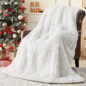 A white yescool weighted blanket draped over a chair next to a Christmas tree with presents under it.