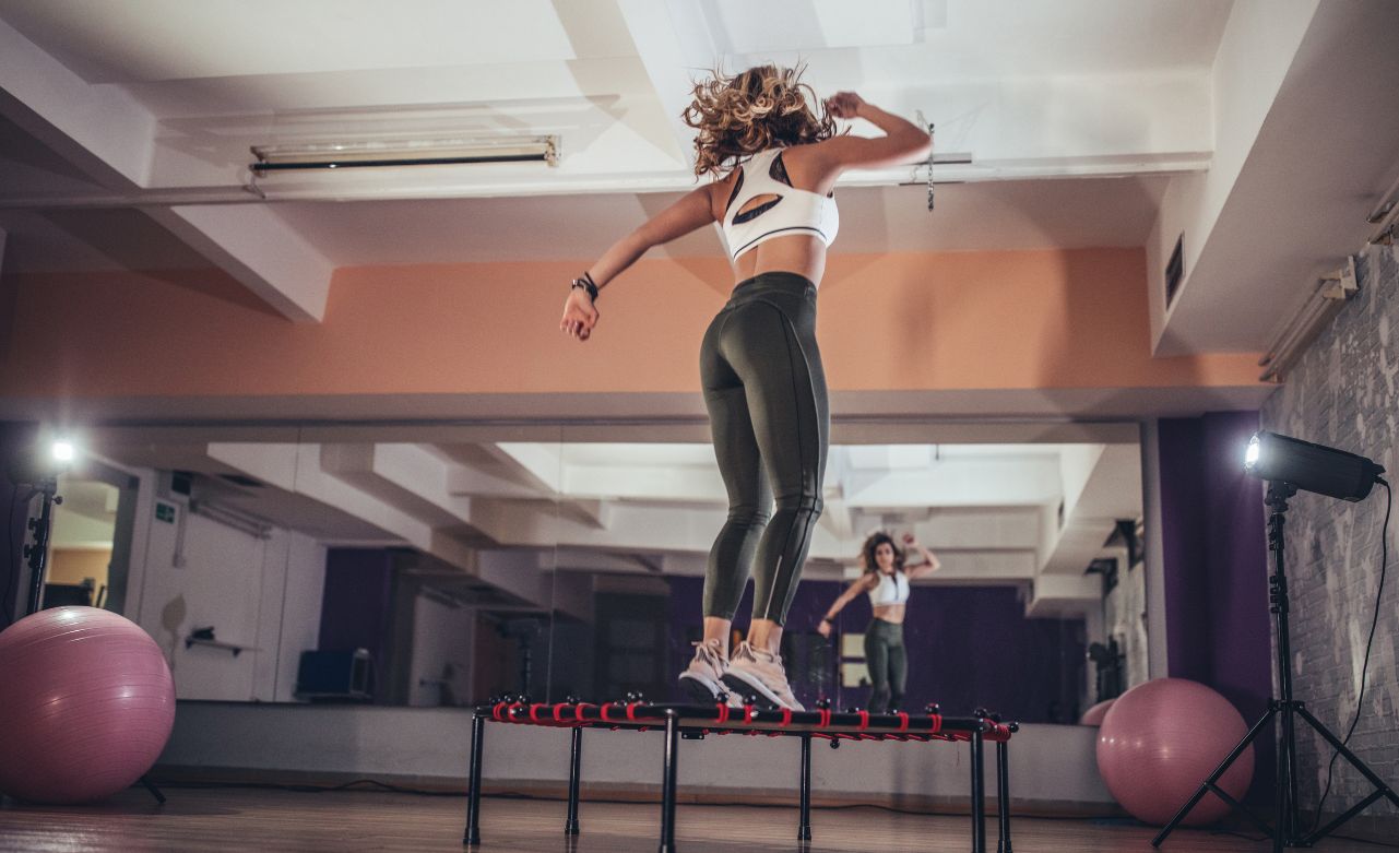 woman-on-rebounder-trampoline A woman jumping on a rebounder in a home gym.